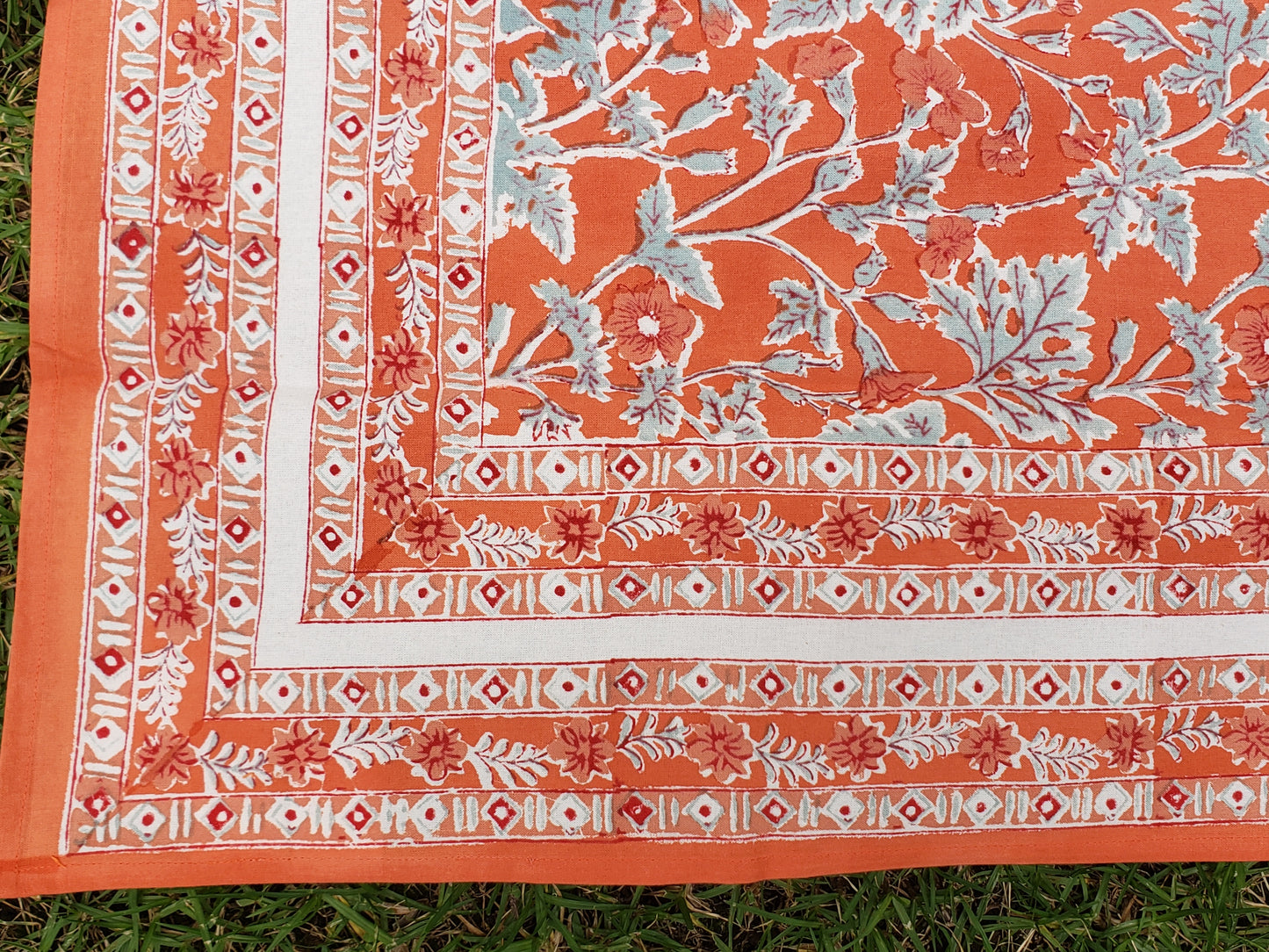 Mantel cuadrado 100% algodón estampado a mano. Geranios fondo naranja