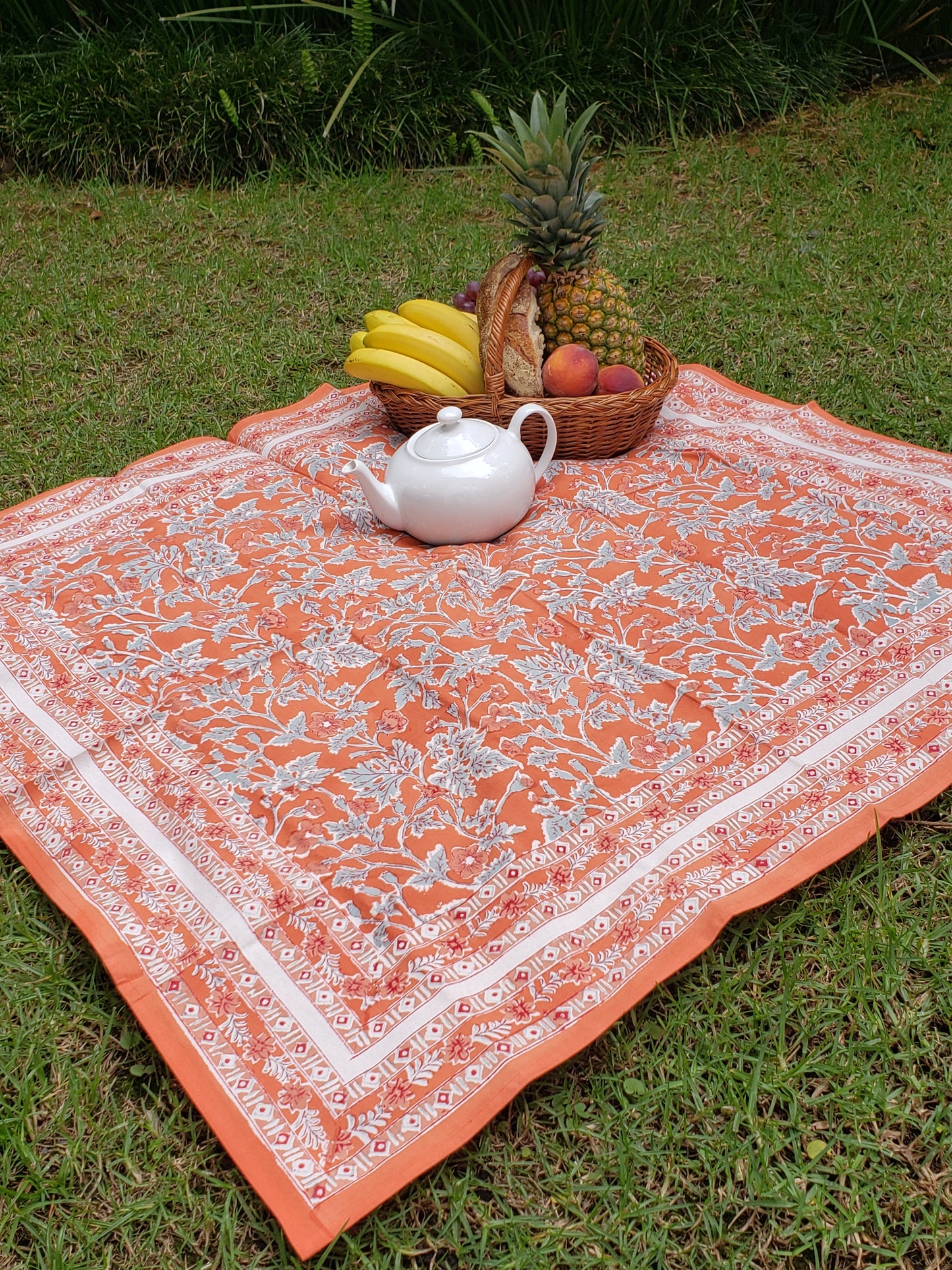 Mantel cuadrado 100% algodón estampado a mano. Geranios fondo naranja