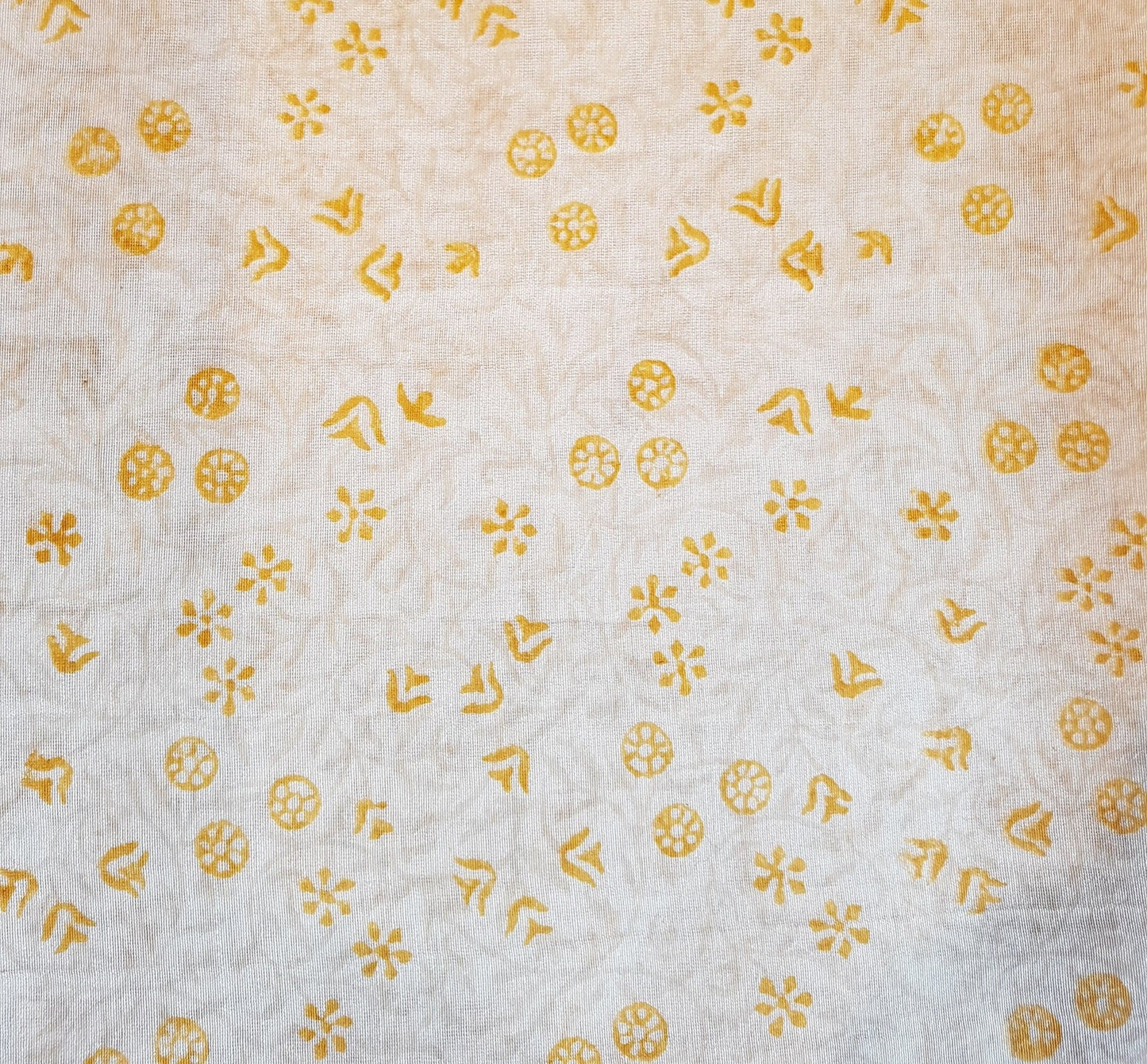 Mantel redondo semitransparente con estampado sútil en amarillo.