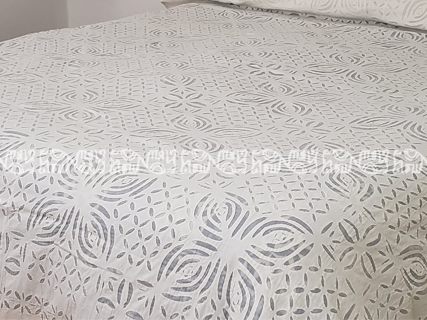 Colcha blanca hindu de algodón calada y cosida a mano sobre base de organdí.