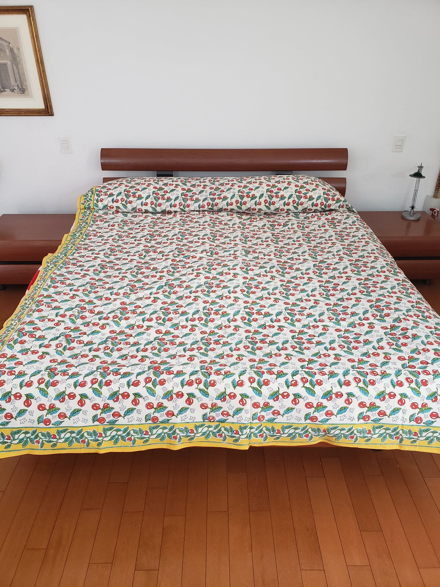Vista delantera de sobrecama 100% algodón estampado a mano, base blanca con cerezas rojas y tallos verdes. Hecho en la India.