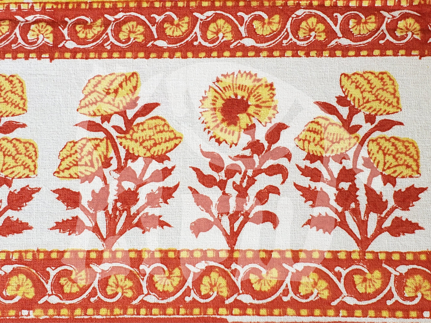 Detalle de borde de sobrecama 100% algodón estampado a mano, base color amarilla con flores rosas y tallos rojos. Hecho en la India.