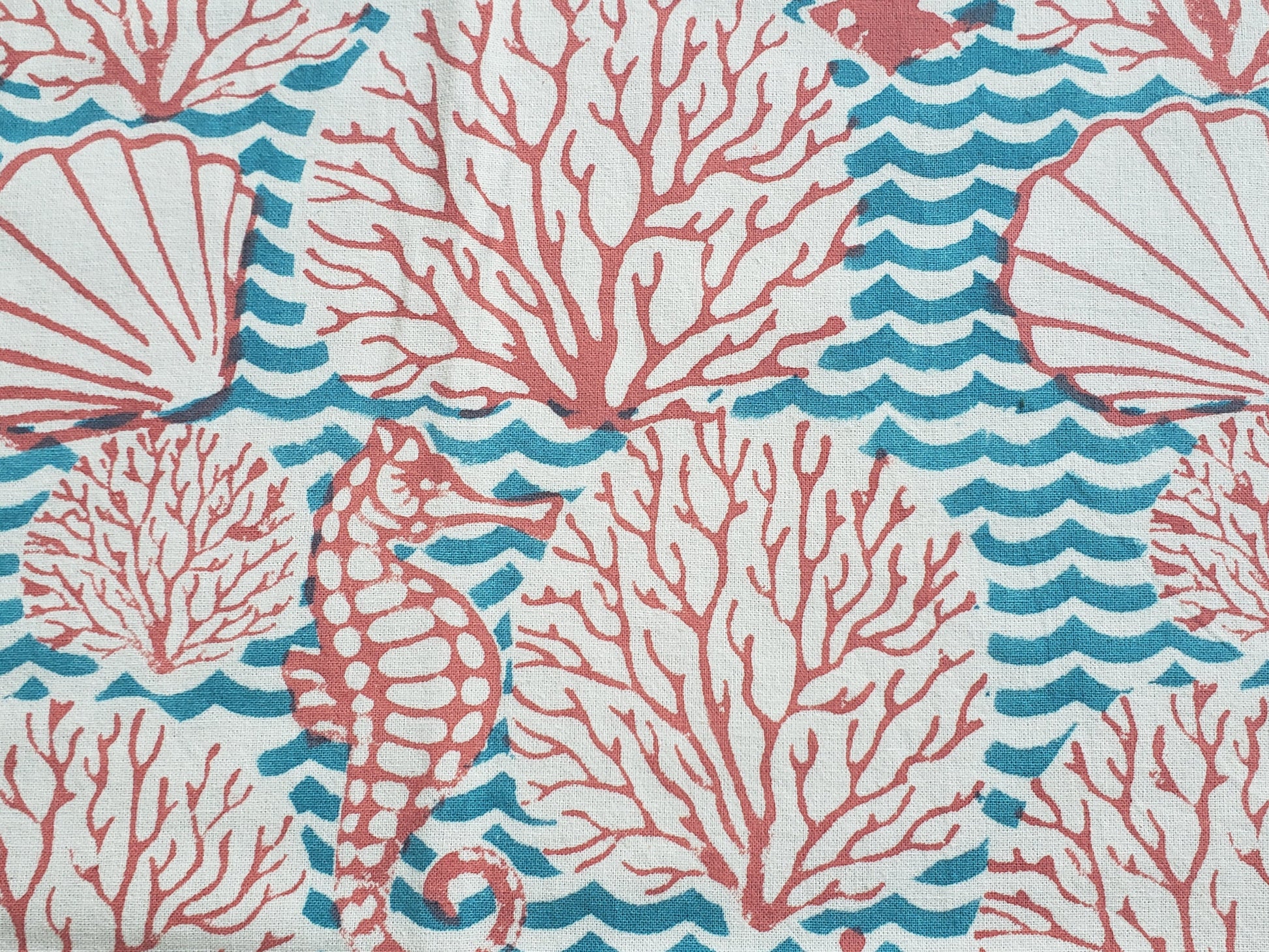 Detalle de estampado de sobrecama 100% algodón estampado a mano, diseño de ondas color turquesa con corales y conchas de mar en color coral. Hecho en la India.