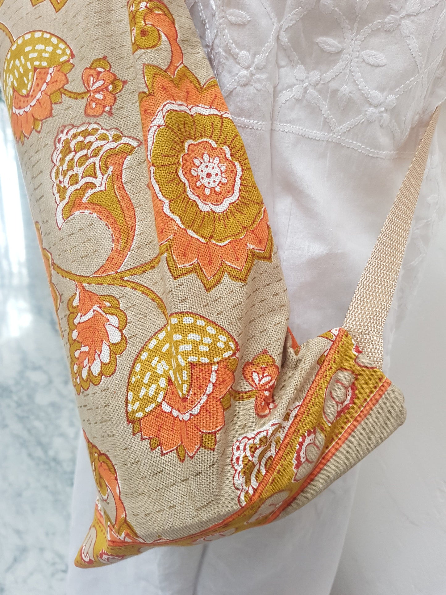 Detalle de correa beige en funda para tapete de yoga 100% algodón, estampada a mano beige con flores naranjas. Hecha en la India.