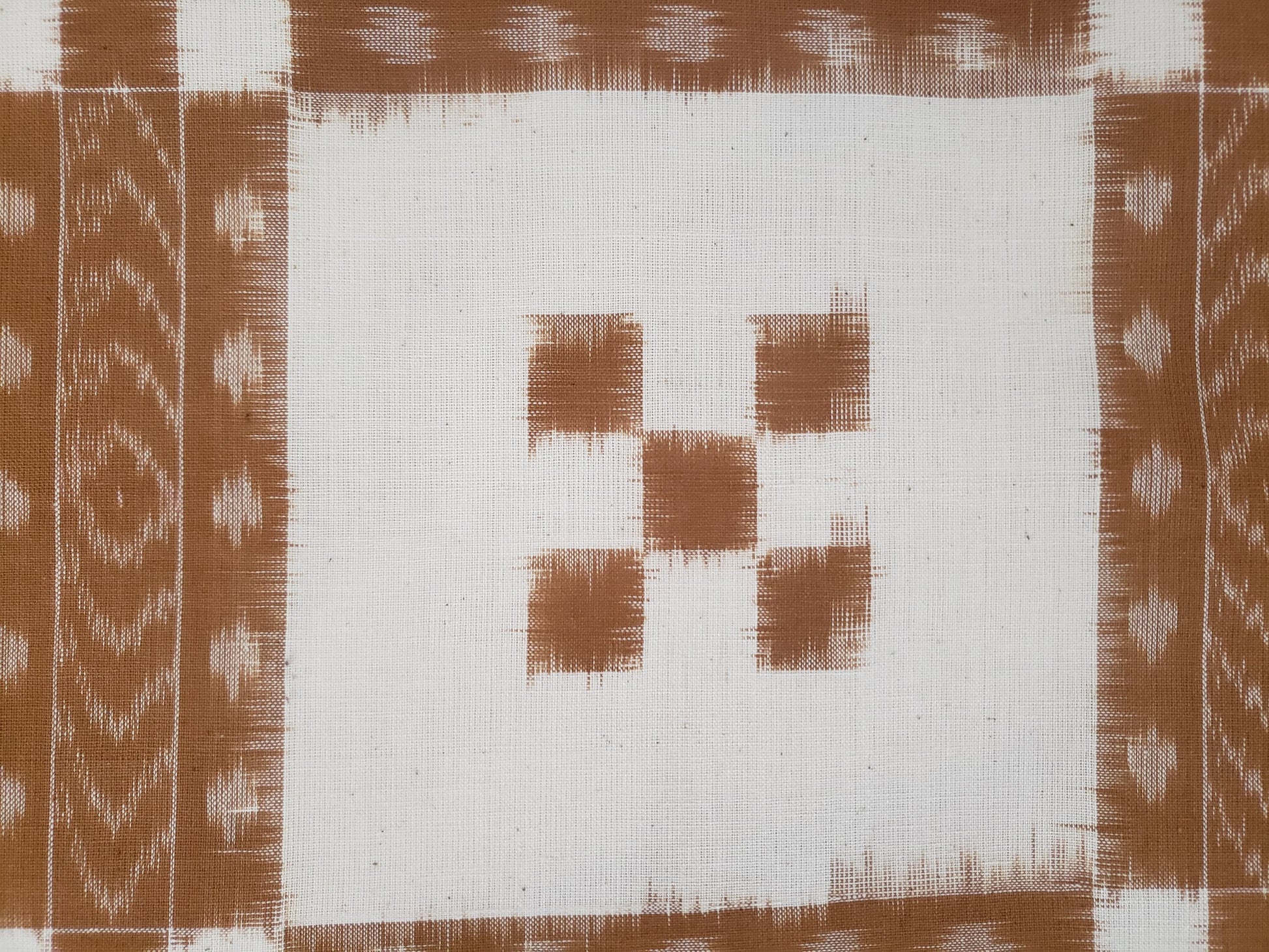 Colcha en manta de algodón tejida en telar formando finos patrones geométricos.