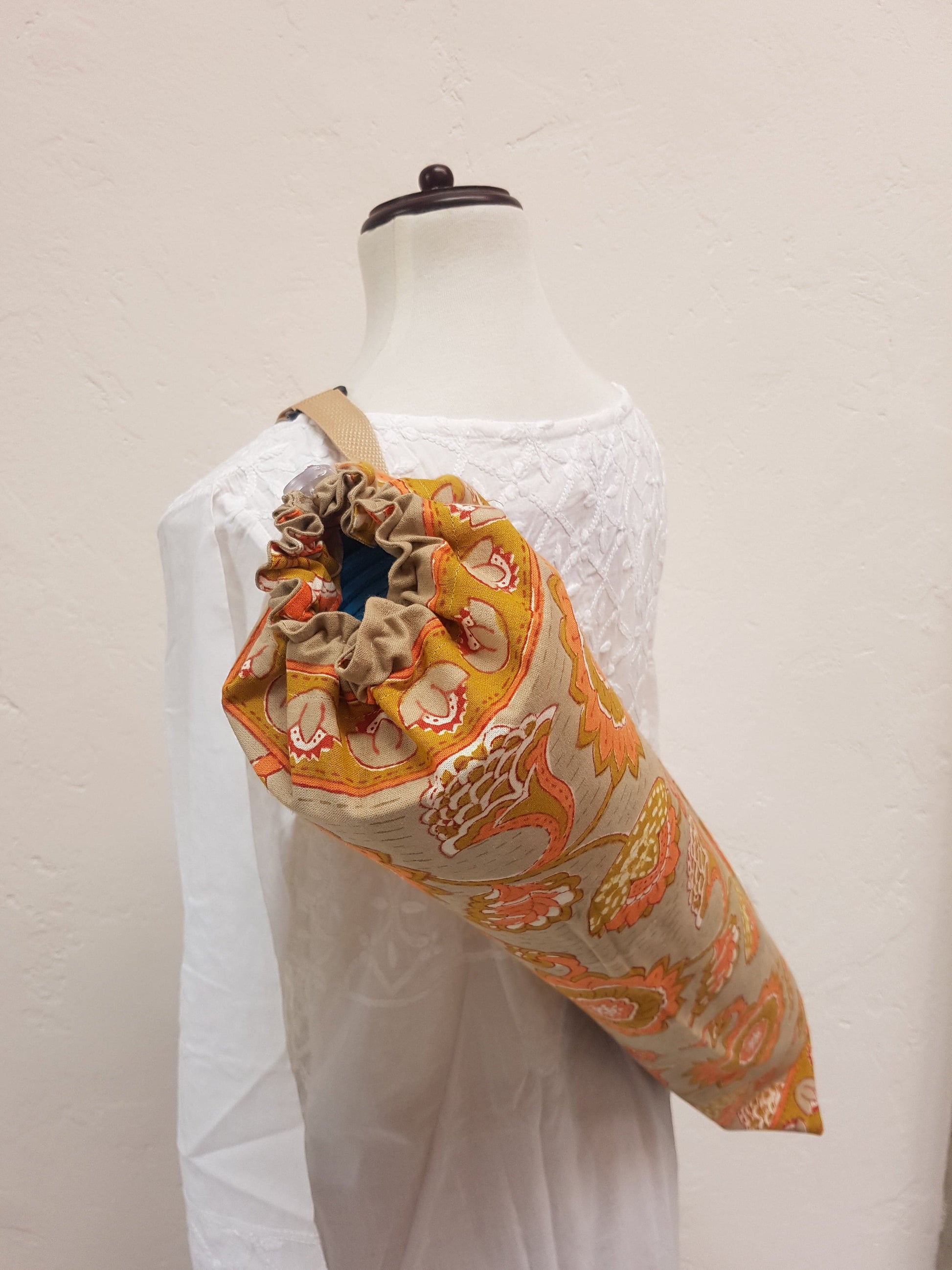 Detalle de jareta en funda para tapete de yoga 100% algodón, estampada a mano beige con flores naranjas. Hecha en la India.