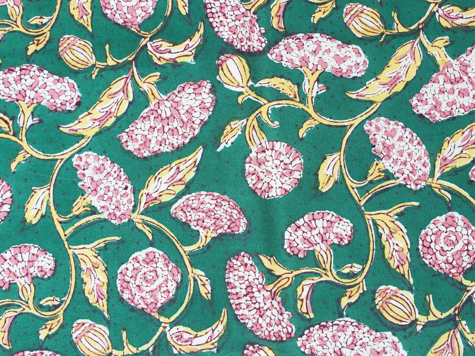 Detalle de estampado de sobrecama 100% algodón estampado a mano, base verde obscuro con flores rosas. Hecho en la India.