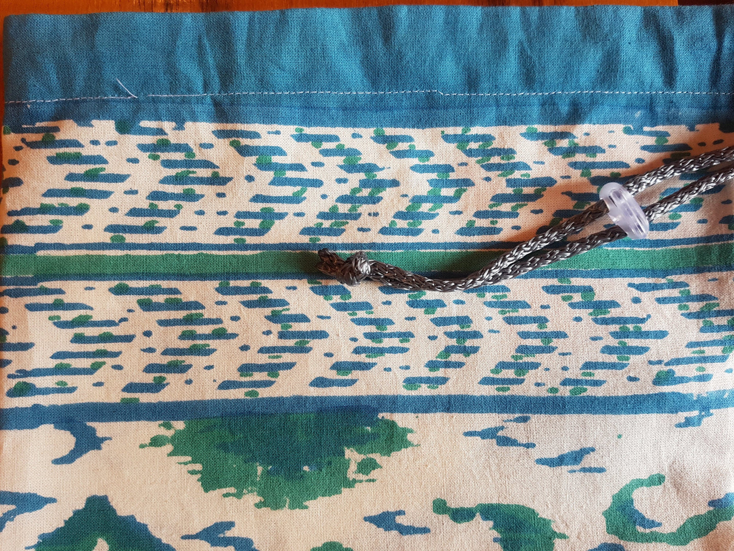 Funda para tapete de yoga 100% algodón, estampada a mano con patrones geométricos en color verde y azul agua. Hecha en la India.