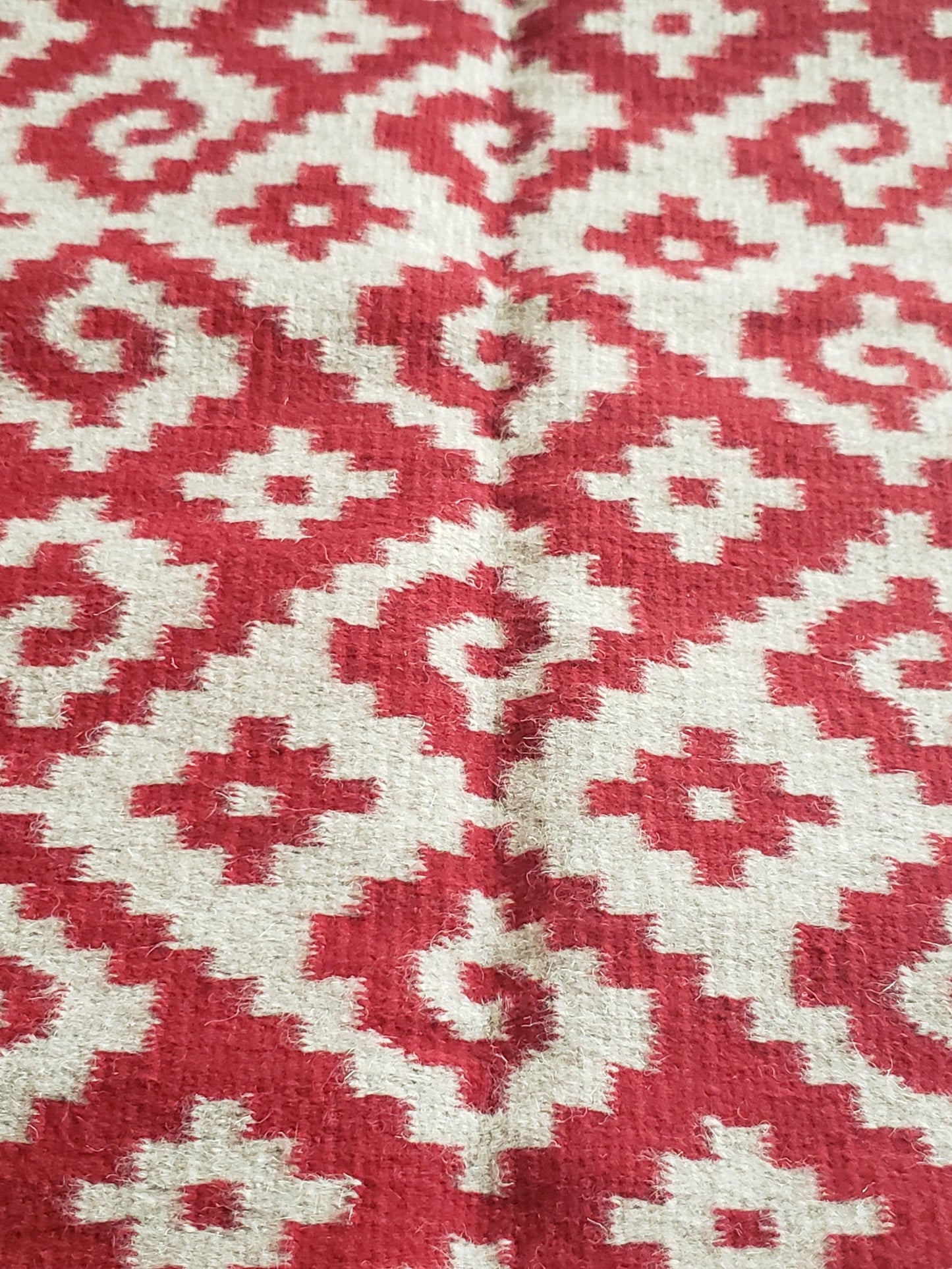 Tapete mexicano, tejido en telar y teñido artesanalmente. Diseño geométrico con grecas color rojo, tinte natural de grana cochinilla.