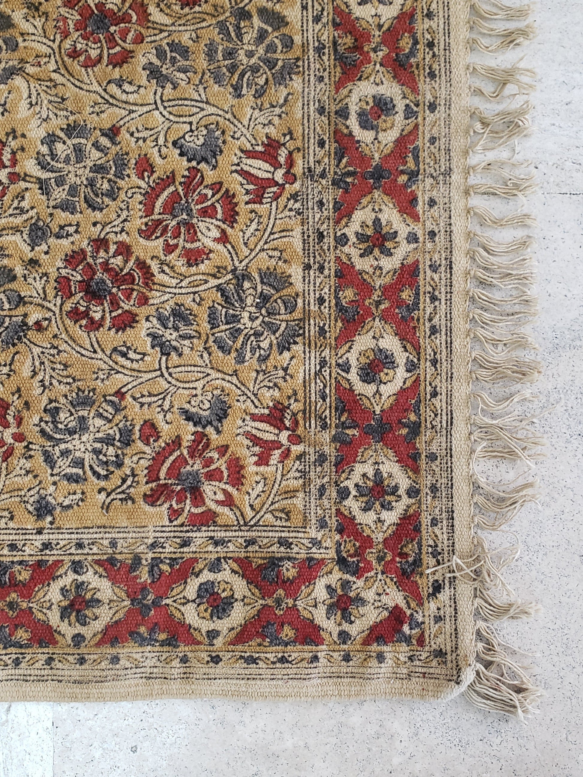 Tapete 100% algodón estampado a mano con diseño tradicional Kalamkari, base ocre con diseño floral en tonos tierra. Hecho en la India.