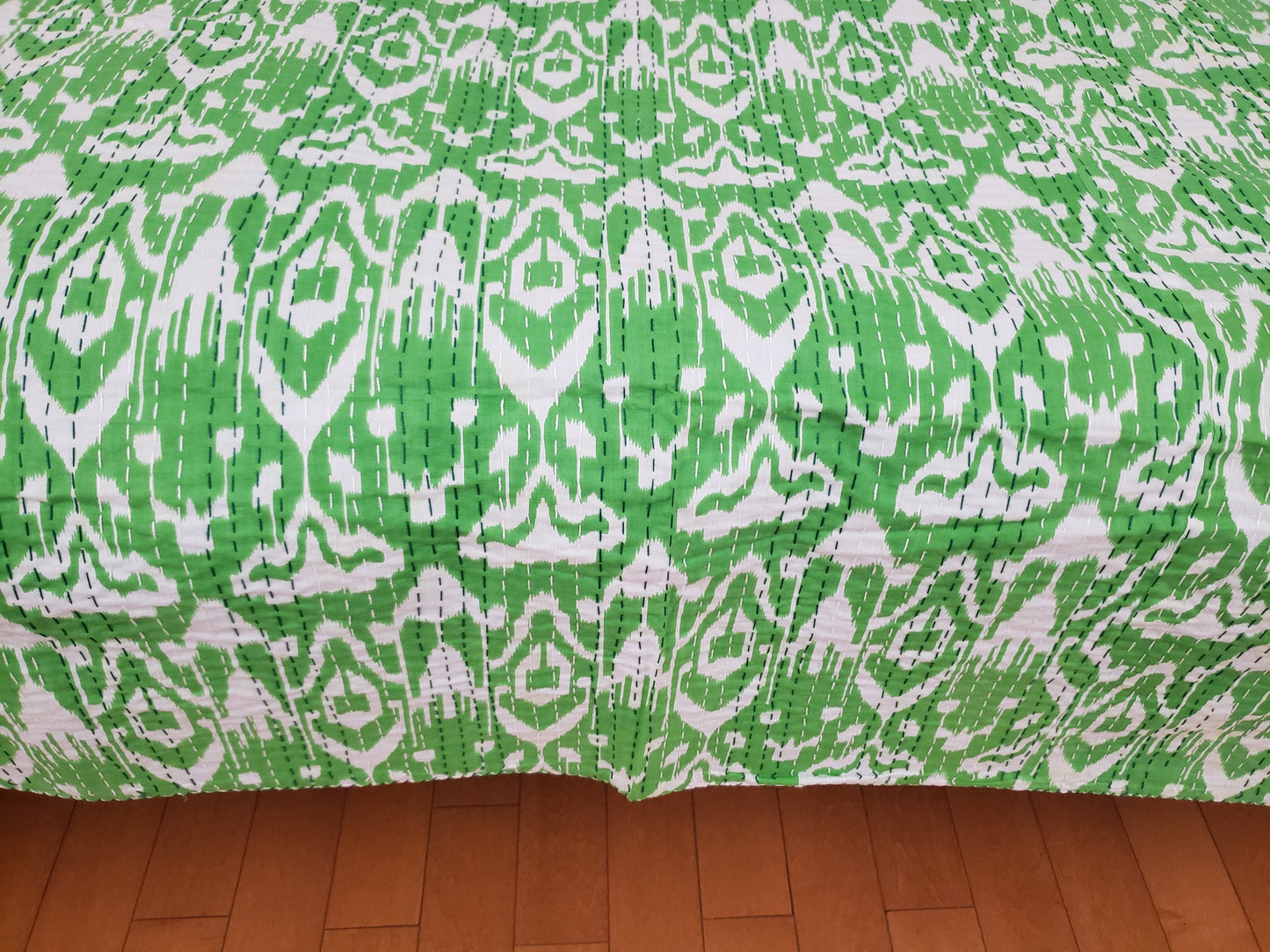 Colcha de algodón hindu con patrones geométricos en color verde.