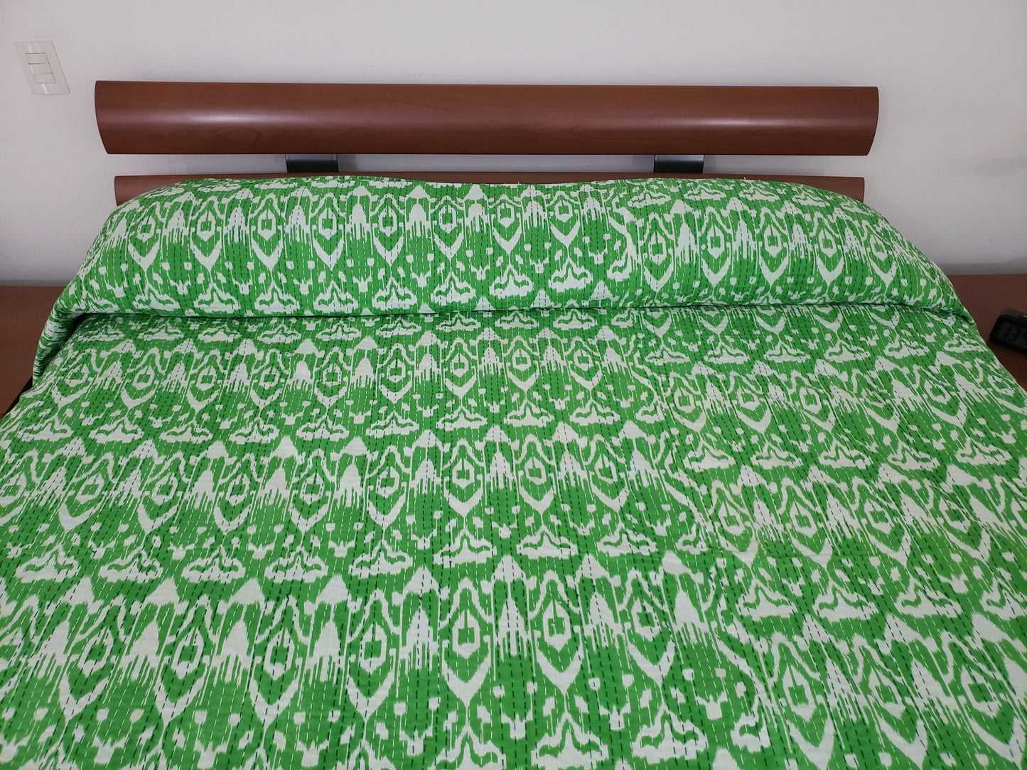 Colcha de algodón con patrones geométricos en color verde.