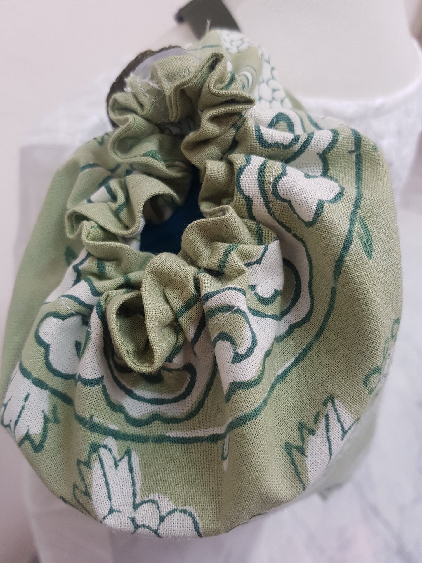 Detalle de jareta en funda para tapete de yoga 100% algodón, estampada a mano verde con mariposas y flores. Hecha en la India.