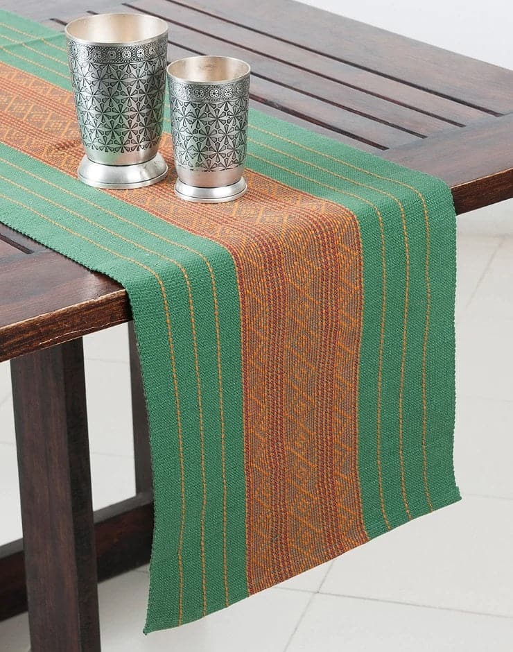 Camino de mesa verde tejido en telar con diseño en medio de grecas ocre. Hecho en la India.